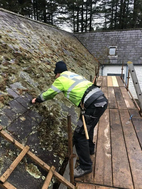 Moss growth on the roof being cleared and broken slates replaced — photo 3